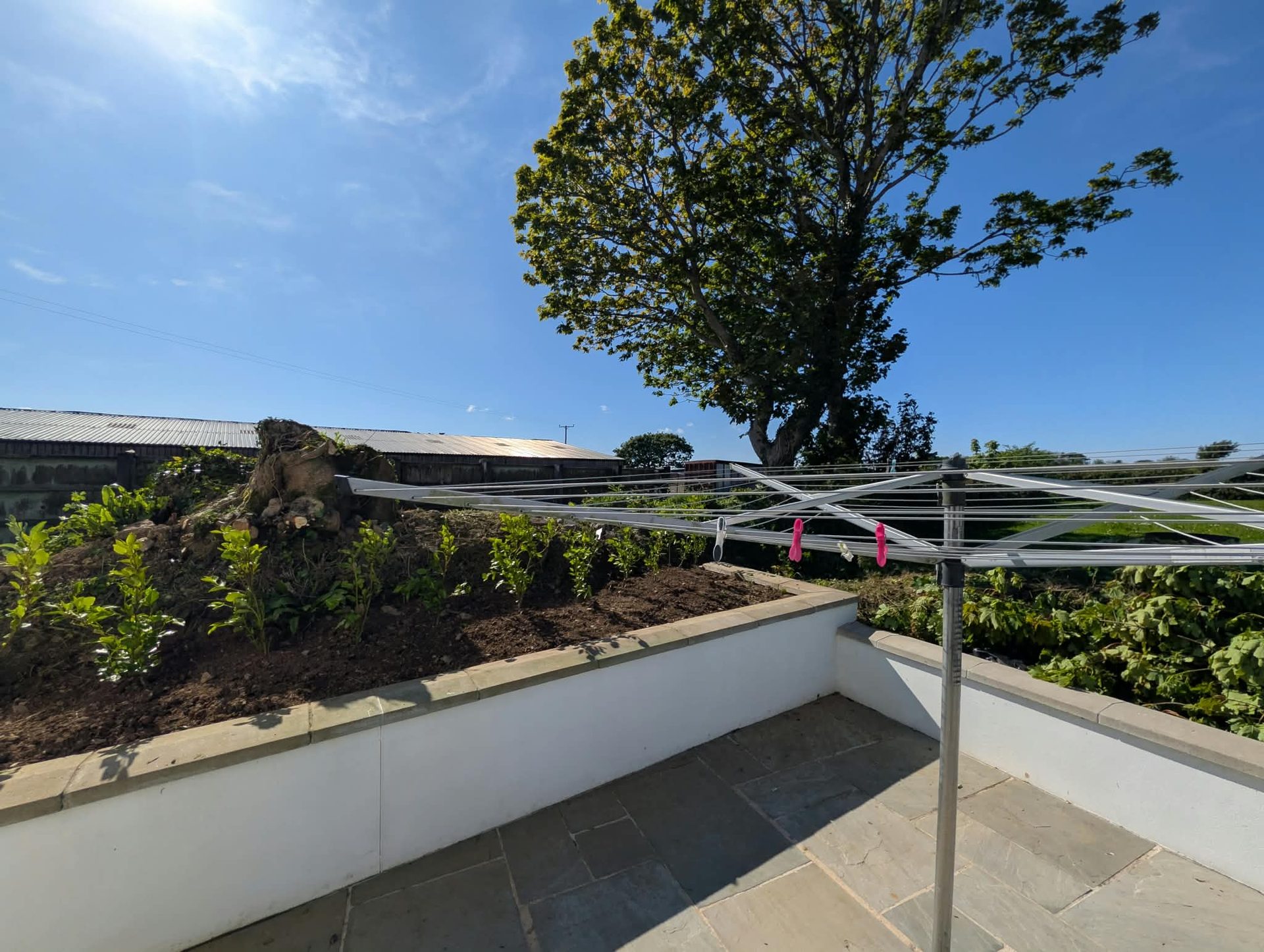 Sandstone patio enclosed by rendered walls with coping stones in Cornwall