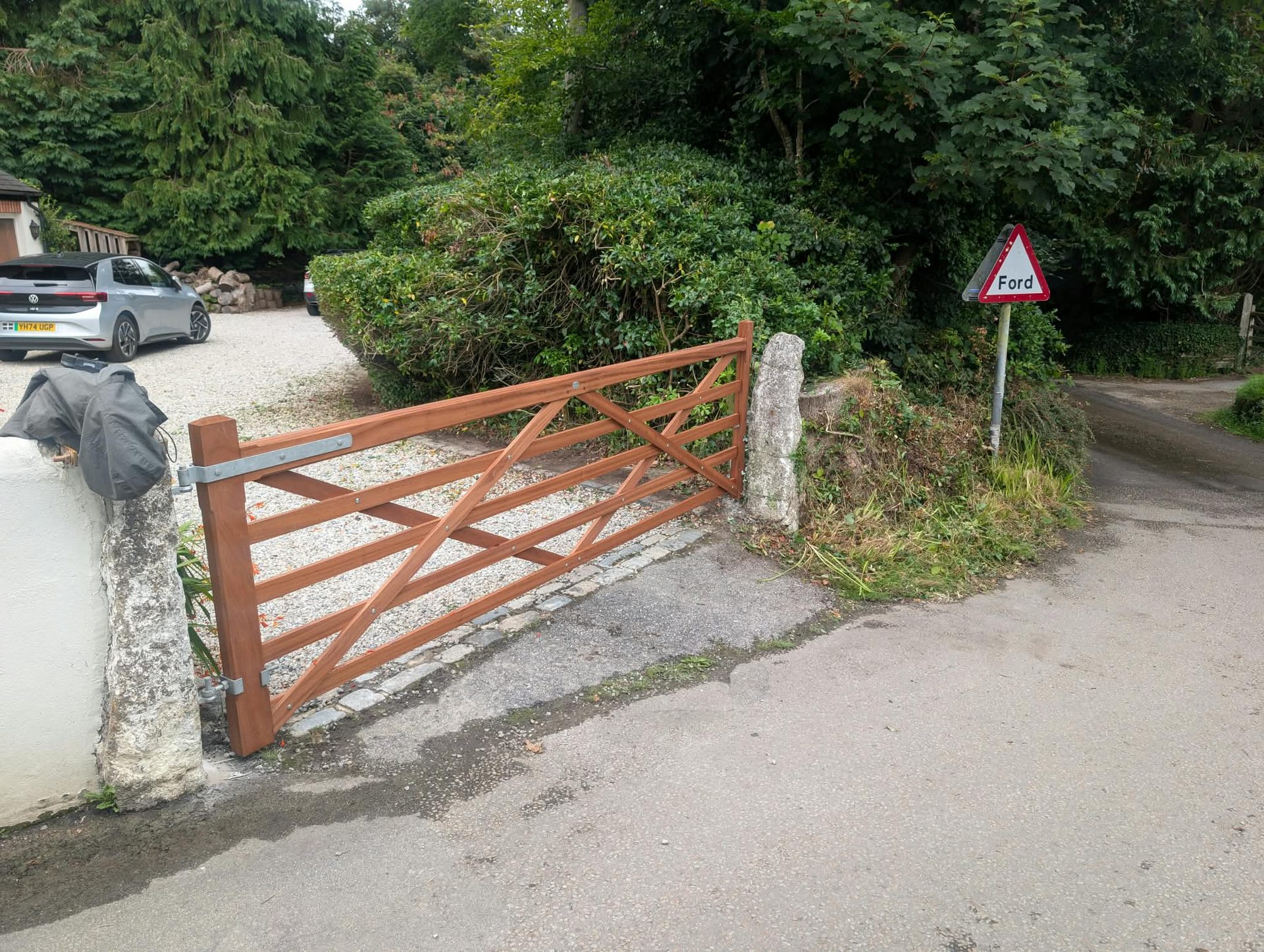 Hardwood five-bar gate between stone gateposts at a rural Cornwall entrance