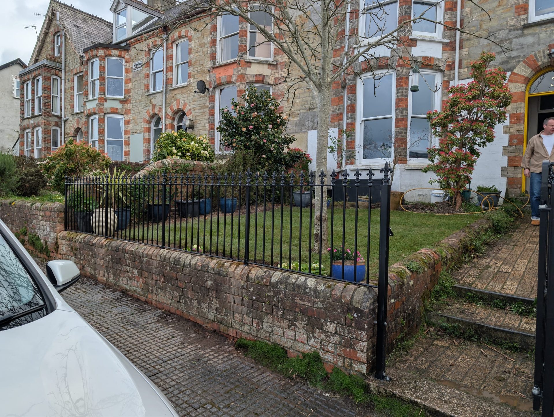 Black metal railings fitted on a brick wall in a Cornwall front garden