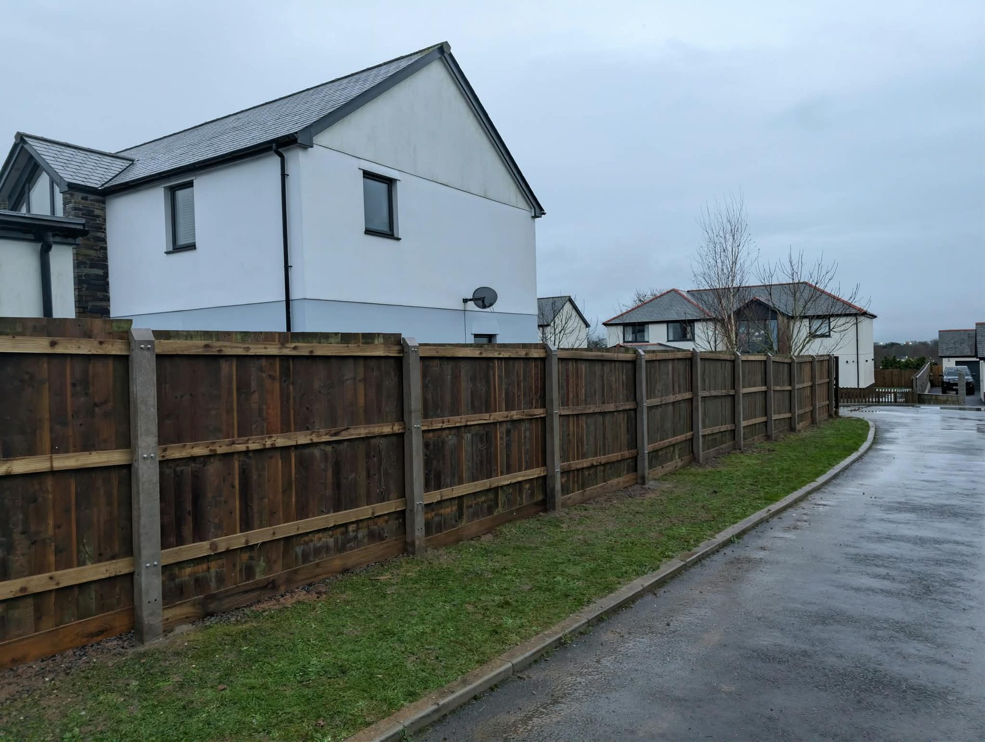 Close-board fence with concrete posts along a residential road in Cornwall