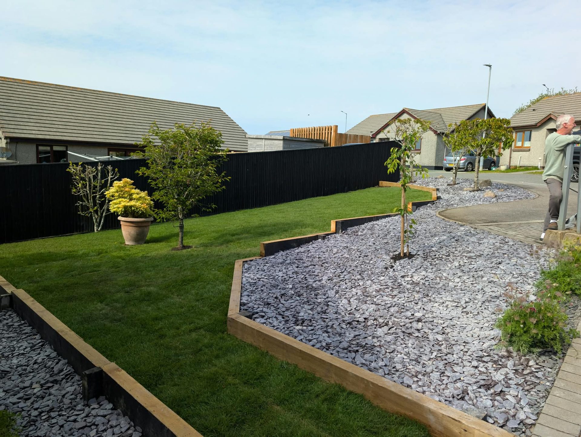 Lawn with sleeper edging, slate chippings and young trees in Cornwall