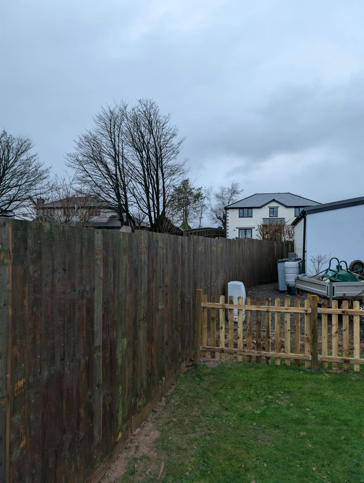 Close-board garden fence with a short picket section in a Cornish back garden