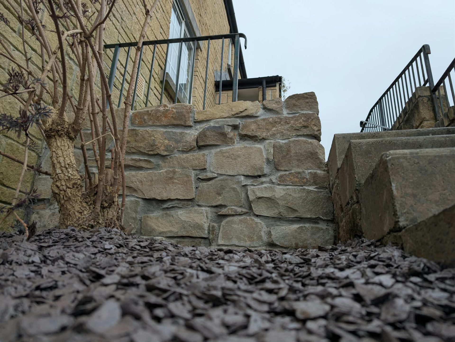 Cornish stone wall built beside steps, finished with slate chippings